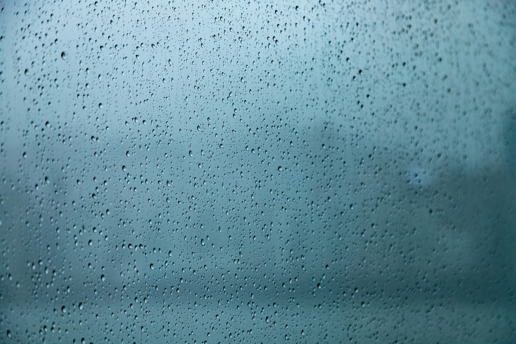Wassertropfen perlen auf einer hydrophoben Glasoberfläche ab