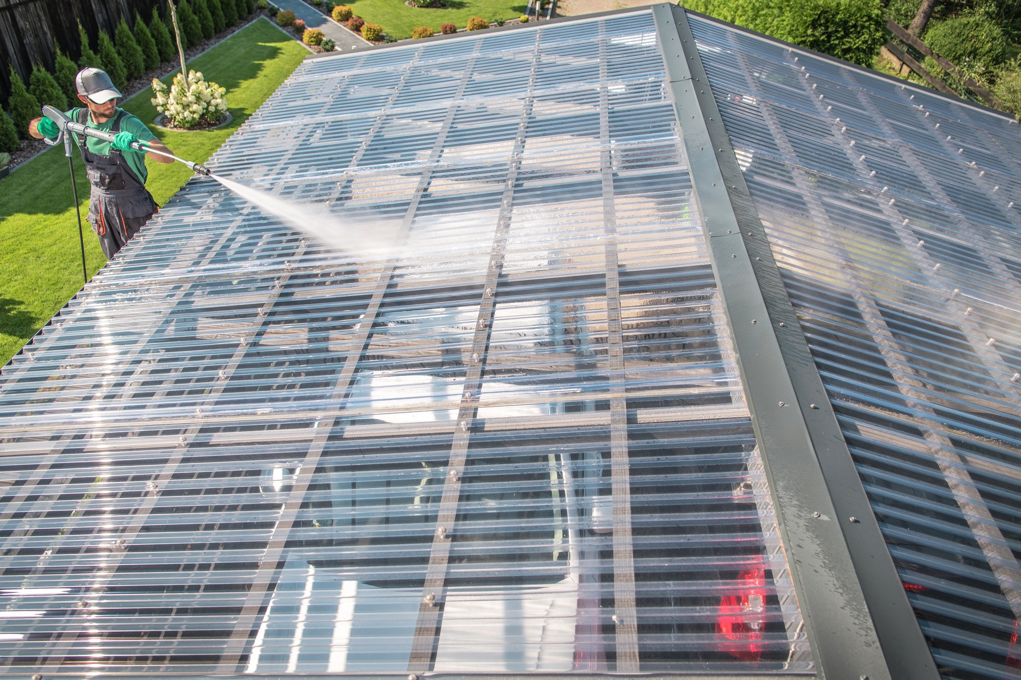 Polycarbonatdach wird mit Teleskopbürste gereinigt